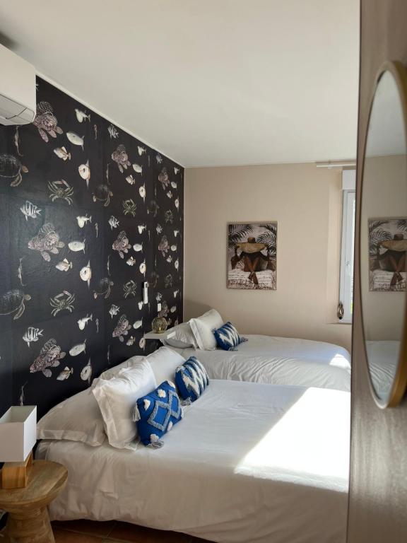 サント・マキシムにあるHotel Princesse D'Azurのベッドルーム1室(ベッド2台、青と白の枕付)