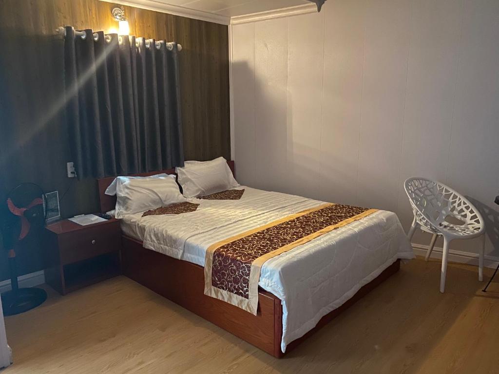 a bedroom with a bed and a table and a chair at Motel Happy House- Hảo in Bạc Liêu