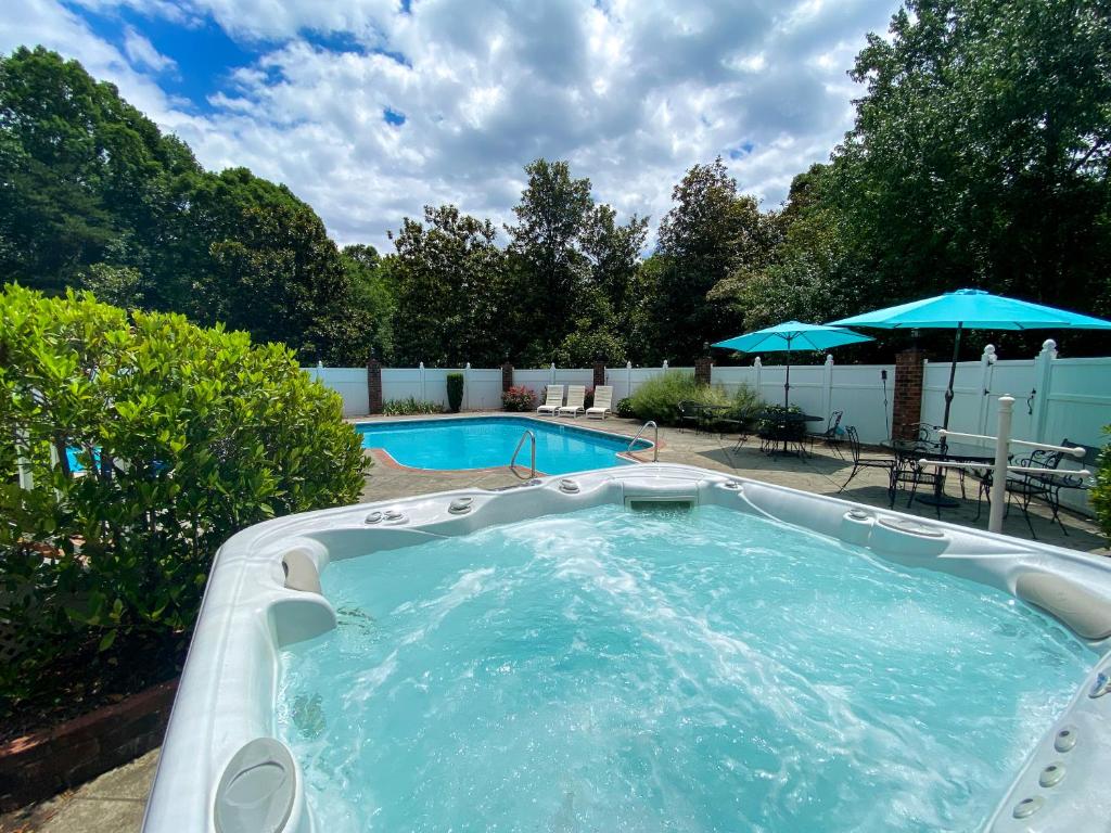una gran piscina con bañera de hidromasaje en un patio en Laurelwood Distinctive old world luxury in Tryon with a swimming pool, hot tub, Game Rm & more en Tryon