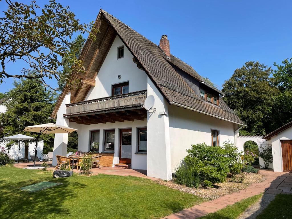 ein weißes Haus mit einem Dach und einer Terrasse in der Unterkunft Messe- & Ferienhaus Gertraud am Ludwigskanal in Wendelstein