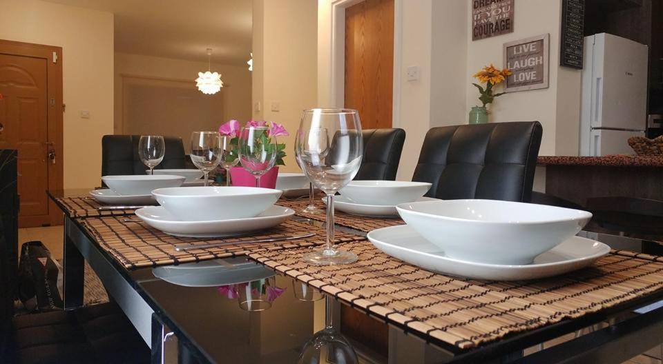 a table with plates and wine glasses on it at Alkinoou Residence in Limassol