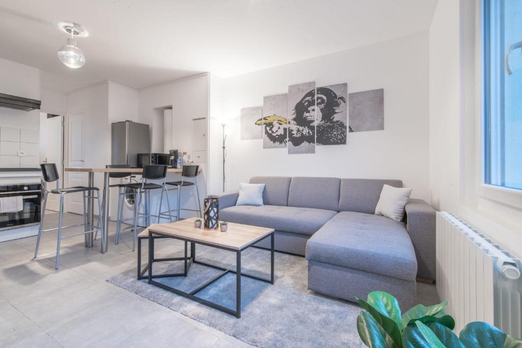 a living room with a couch and a table at L'URBAIN - Appartement proche gare in Saint-Nazaire