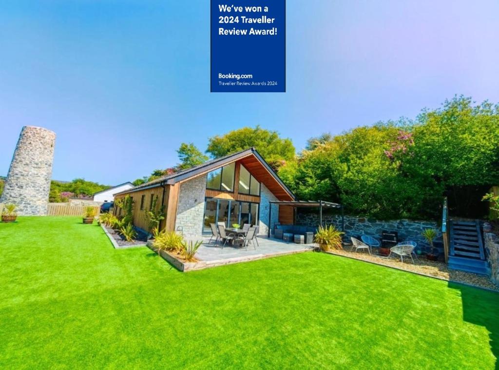 a house with a lawn in front of it at New build Luxurious PALMA VILLA IN CORNWALL! 4miles EDEN PROJECT, 4 miles Beach & Harbour! Open plan, One level Living area Ground floor, Private location, Encllosed Garden, Underfloor Heating, Coffee Machine,near WALKING-CYCLING PATH in St Austell