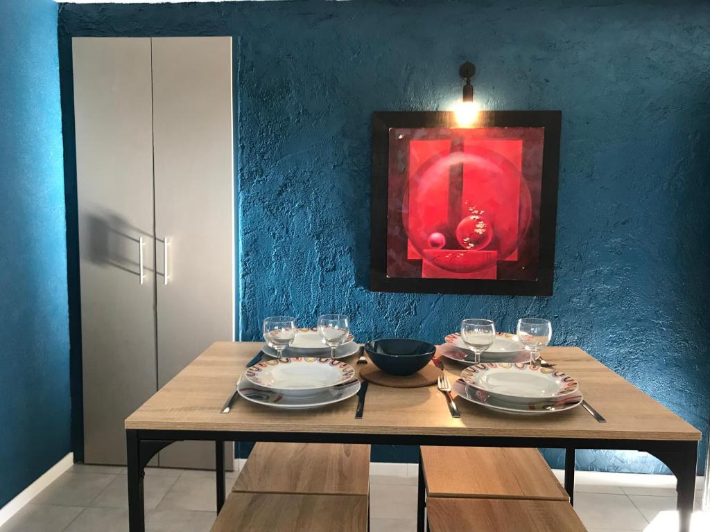 une table en bois avec des assiettes et des verres à vin dessus dans l'établissement Oustau Aix, à Aix-en-Provence