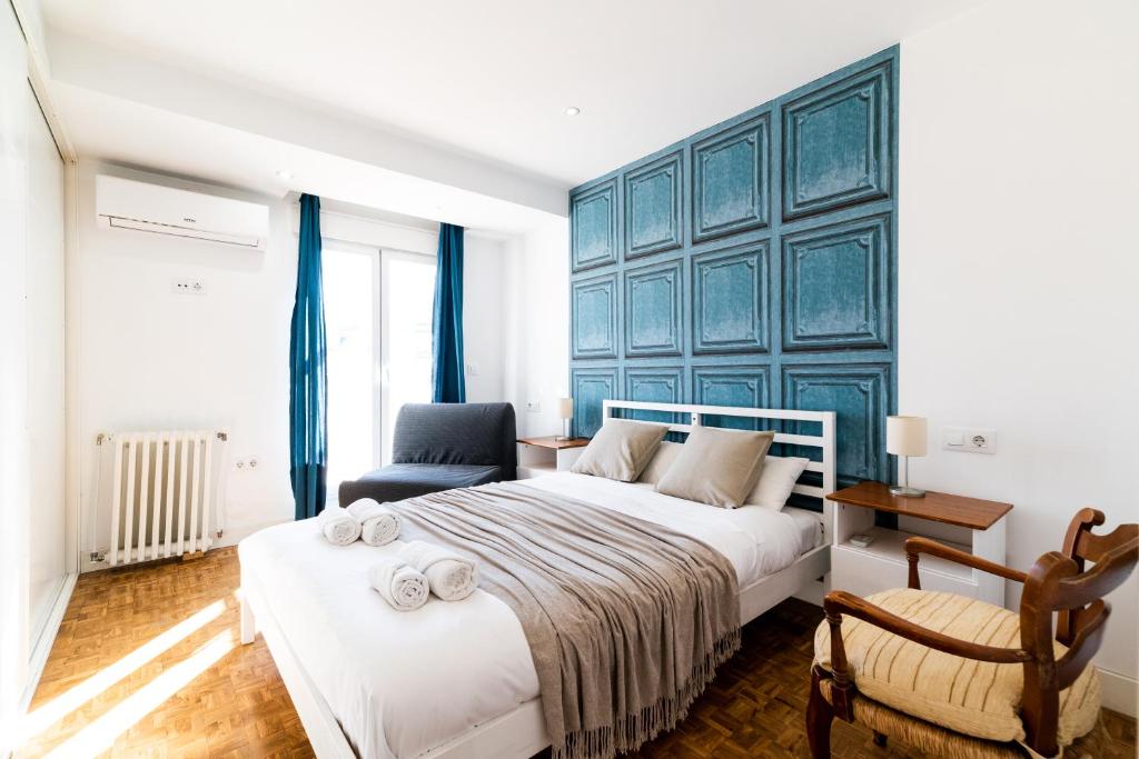 a bedroom with a large bed and a chair at Neptuno Ático, con terraza in Granada