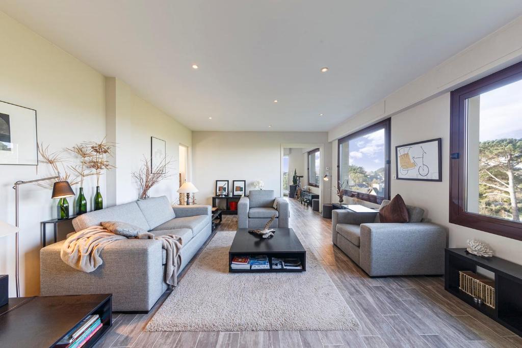 a living room with a couch and two chairs at Appartement vue sur la baie de St Briac in Saint-Briac-sur-Mer