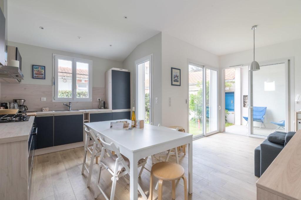 cocina y sala de estar con mesa blanca y sillas en Maison familiale avec vue sur mer, en La Bernerie-en-Retz