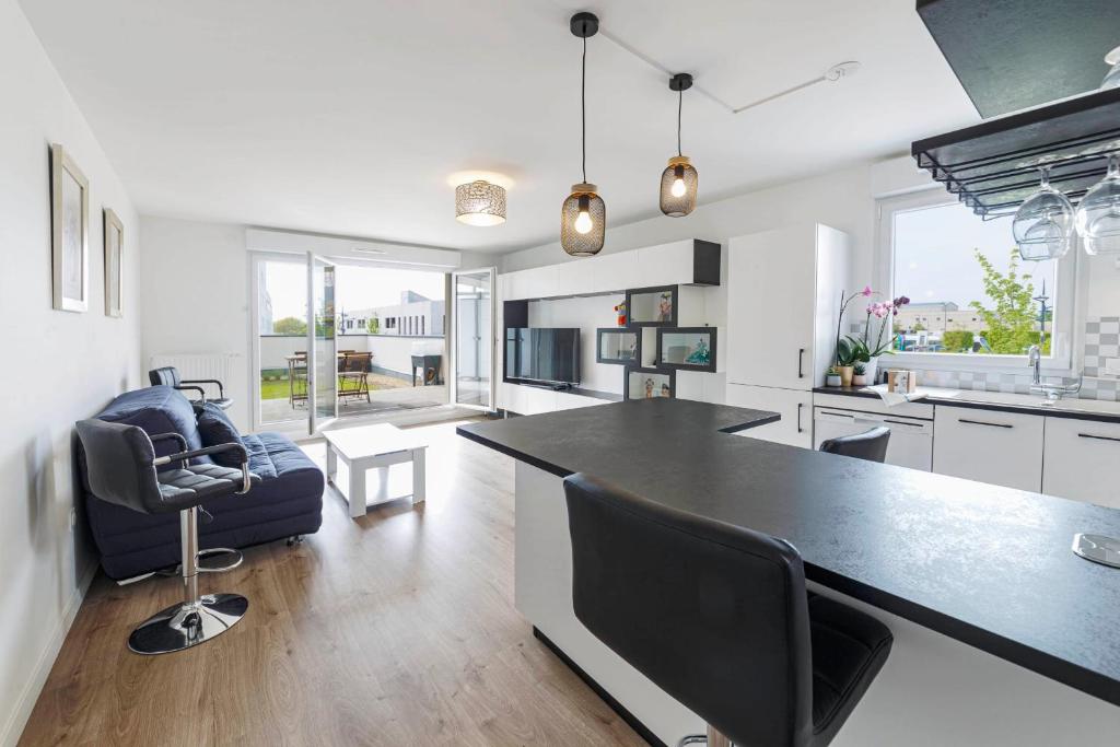 kuchnia i salon z dużym czarnym blatem w obiekcie Bel appartement moderne avec jardin w mieście Angers