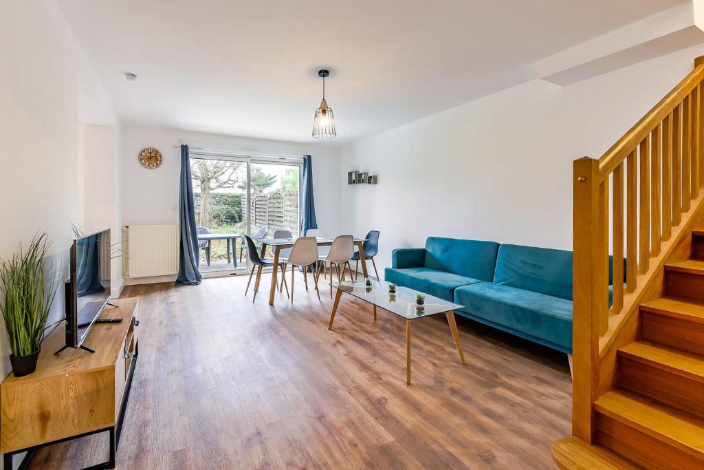 een woonkamer met een blauwe bank en een tafel bij Le Soleil Levant - T6 proche centre in Angers