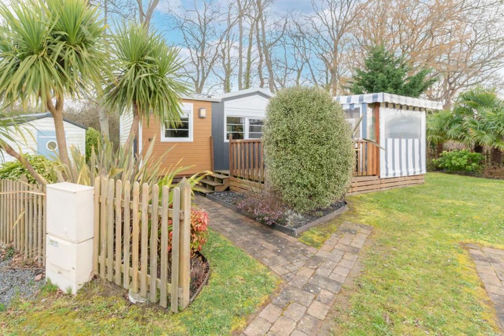 a house with a fence in a yard at Bois d'amour - Piscine - Terrasse in Dinard
