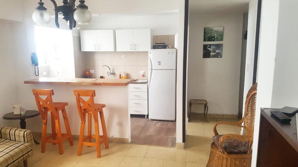 eine Küche mit einem weißen Kühlschrank und 2 Barhockern in der Unterkunft Departamento Céntrico in Mar del Plata