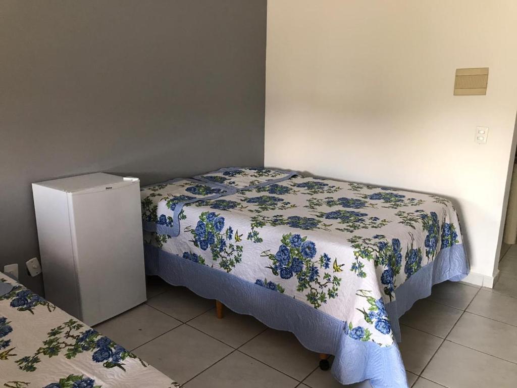 a small bedroom with two beds and a refrigerator at Pousada Vida feliz in Águas de Lindoia