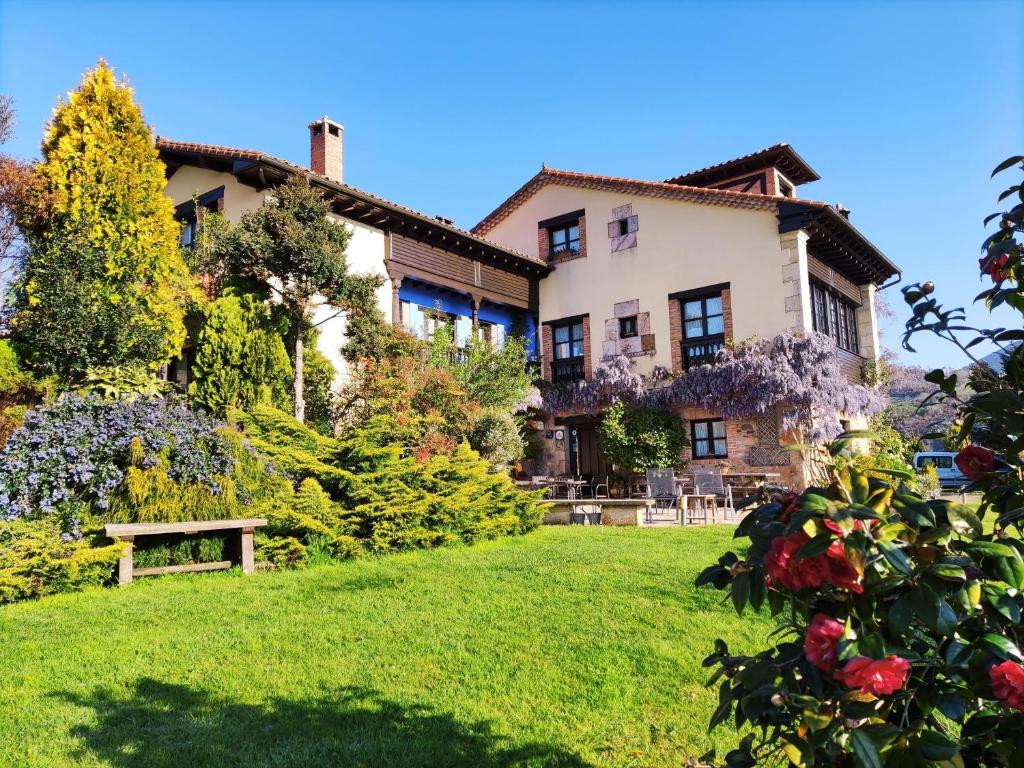 una casa con un prato verde davanti di Heredad de la Cueste a Llenín