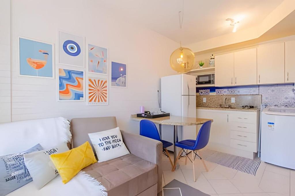 a living room with a couch and a table in a kitchen at Estúdio Próximo a Beira Mar in Florianópolis