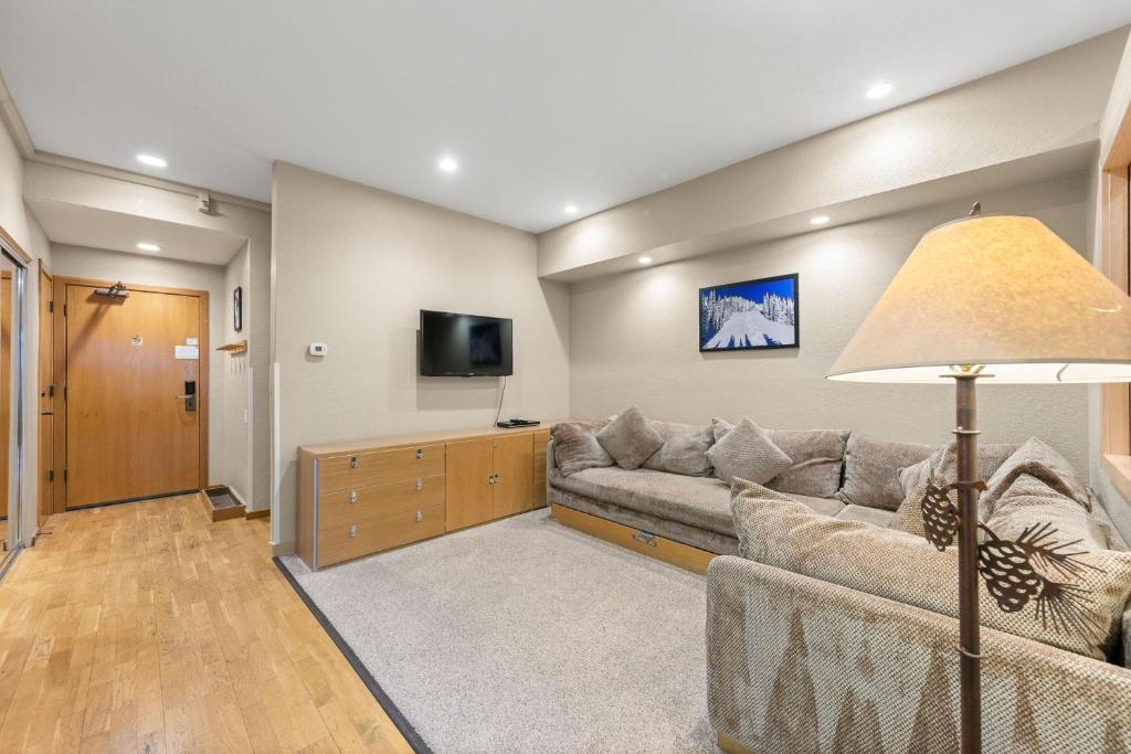 ein Wohnzimmer mit einem Sofa und einem Flachbild-TV in der Unterkunft Studio #211 in Olympic Valley