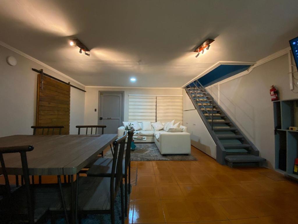 ein Wohnzimmer mit einem Esstisch und einer Treppe in der Unterkunft alojate en la playa litera baño compartido 