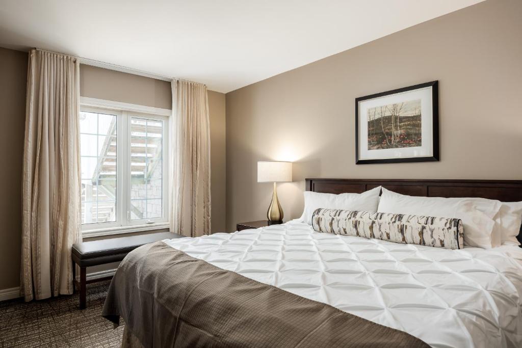 um quarto com uma cama grande e uma janela em Horseshoe Valley Suites - The Glade em Shanty Bay