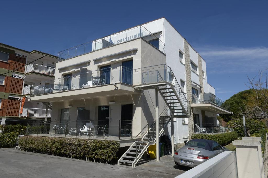 - un bâtiment blanc avec un balcon et une voiture dans l'établissement Apartamentos Castellmar, à Castelldefels