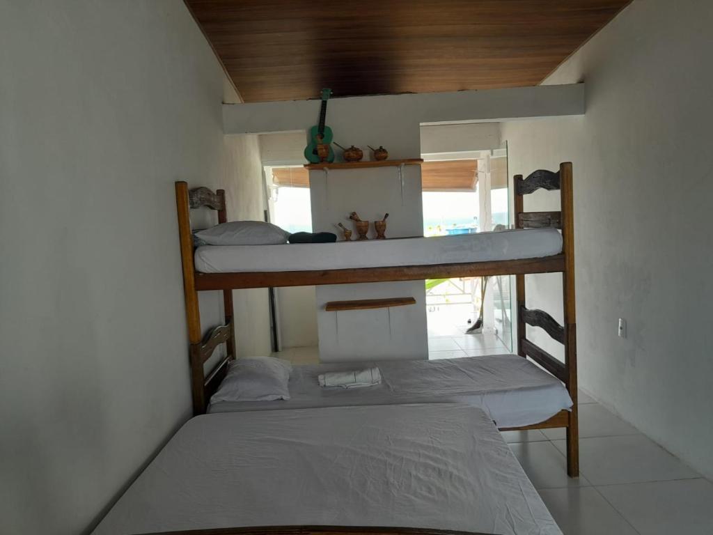CairuにあるCasa da Indiaの二段ベッド2台とベッド1台が備わる客室です。