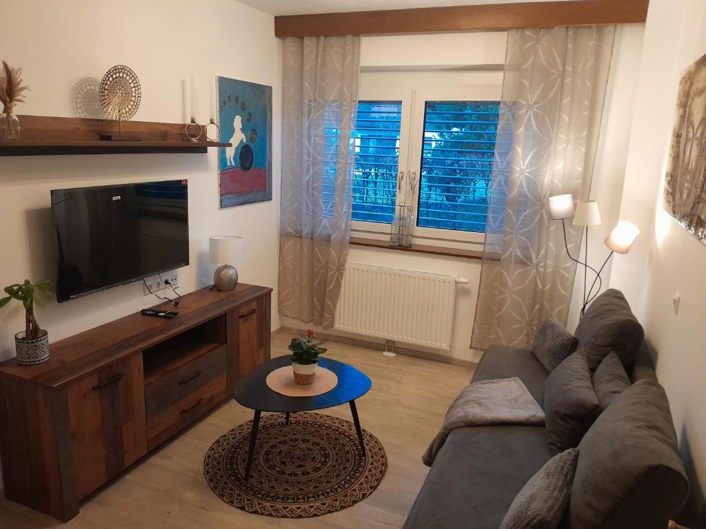 een woonkamer met een bank en een tv bij Ferienwohnung Christina in Möllbrücke
