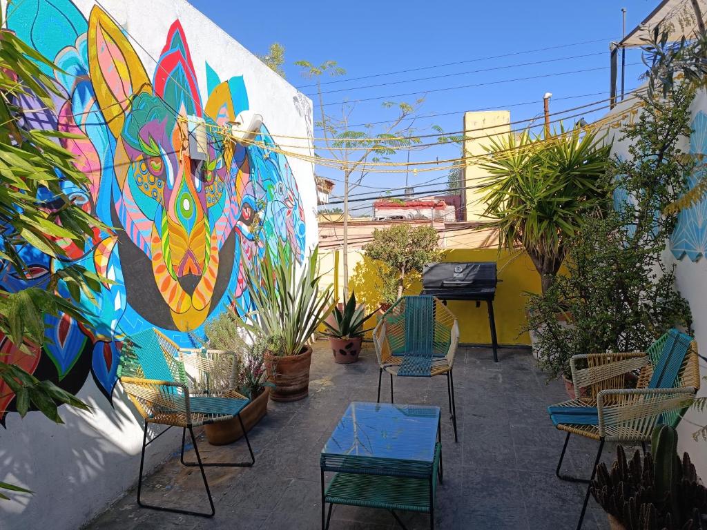 un patio con sillas y una pared con un mural en Monkey Safari Hostel en Querétaro