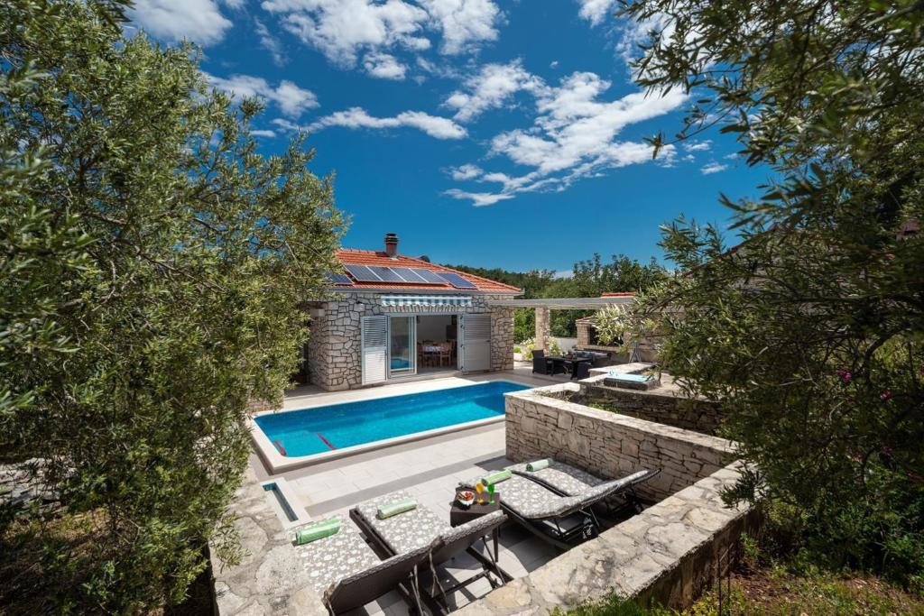 une arrière-cour avec une piscine et une maison dans l'établissement Holiday Home Ivona, à Vela Luka