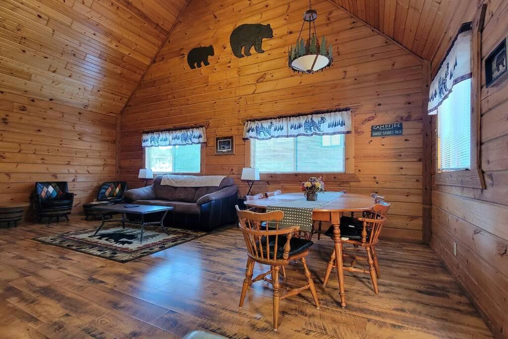 un soggiorno con tavolo e sedie in una cabina di The Grizzly Den Cabin Warrens WI a Warrens