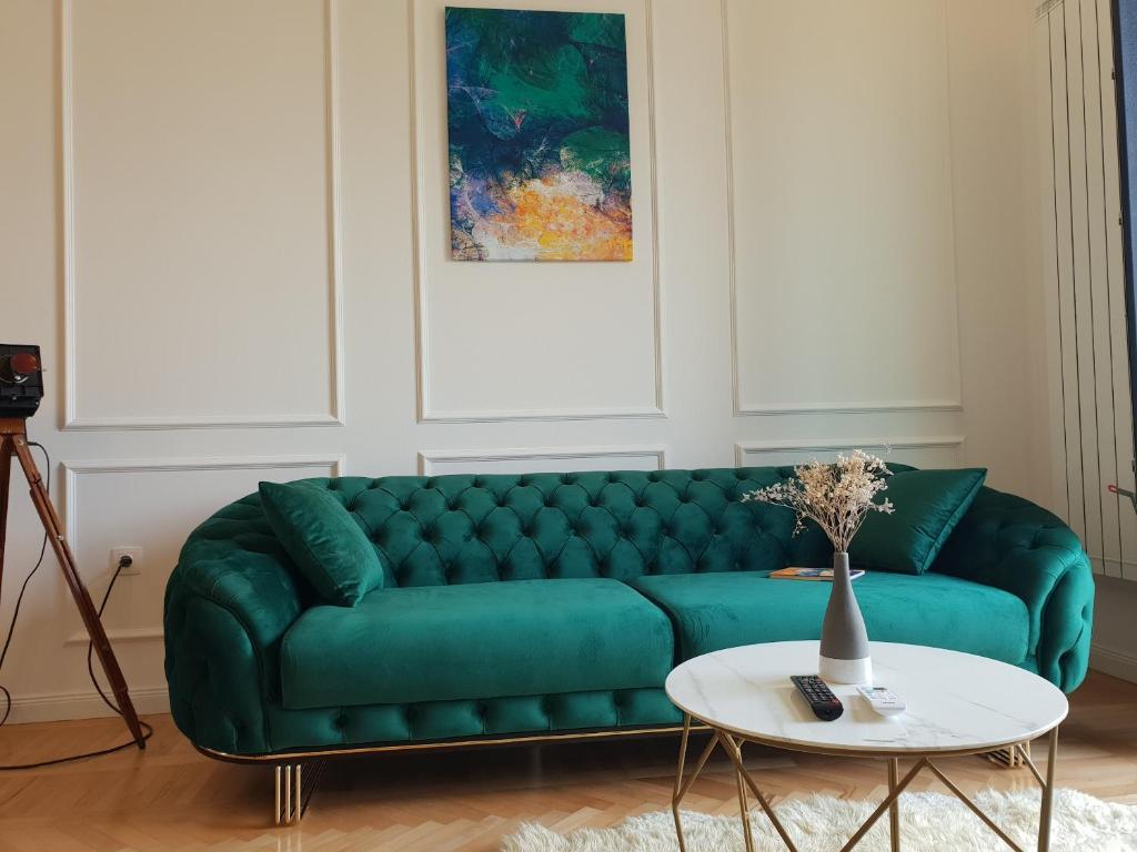 un sofá verde en una sala de estar con mesa en FRONTEX CityCenter Galati - disscount on Google!, en Galaţi