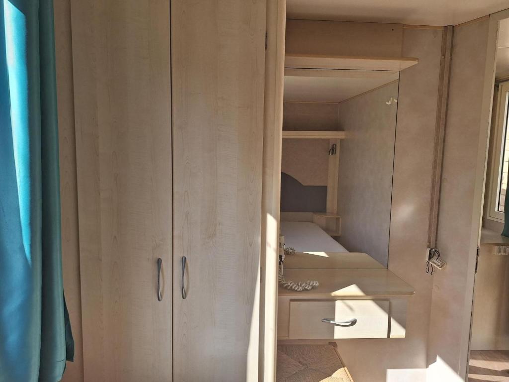 een kast in een kamer met enkele planken bij Comfortable campsite-chalet G12 Tuscany near sea in Viareggio