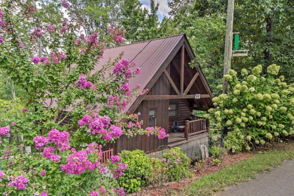 a small cabin with pink flowers in front of it at Majestic View Hideaway in Sevierville