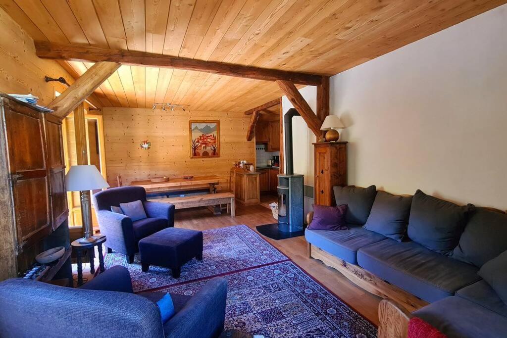 a living room with a couch and chairs in a cabin at Appartement de charme, vue sur les montagnes. in Aiguilles