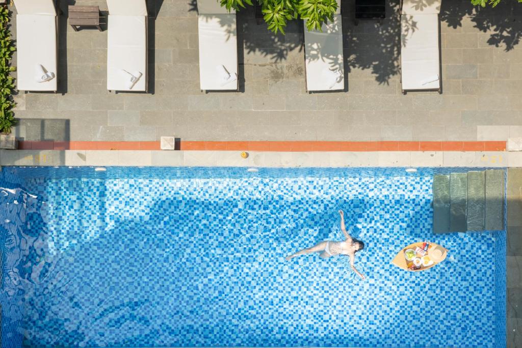 een zwembad met een dolfijn en een bal in het water bij RAON Hoian Beach in Hội An