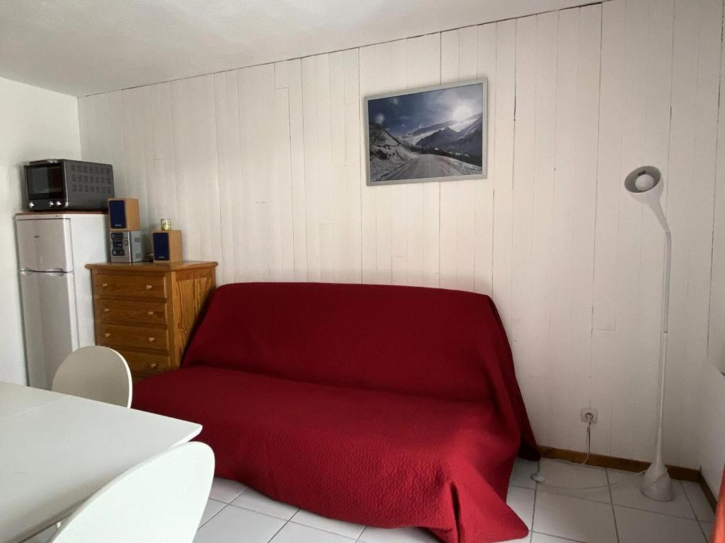Cette chambre comprend un canapé rouge et un réfrigérateur. dans l'établissement Residence Tigny - 2 Pièces pour 4 Personnes 34, à Valloire