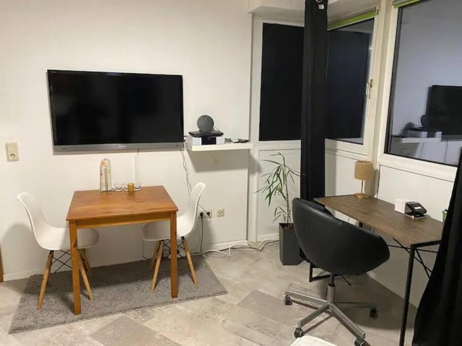 a room with a desk and a table and a television at Dortmund City! Apartment DREAM in Dortmund