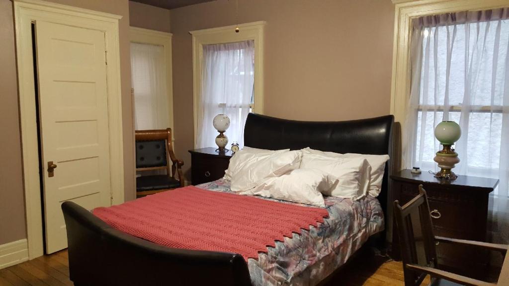 1 dormitorio con 1 cama con manta roja en Scottwood Inn, en Toledo