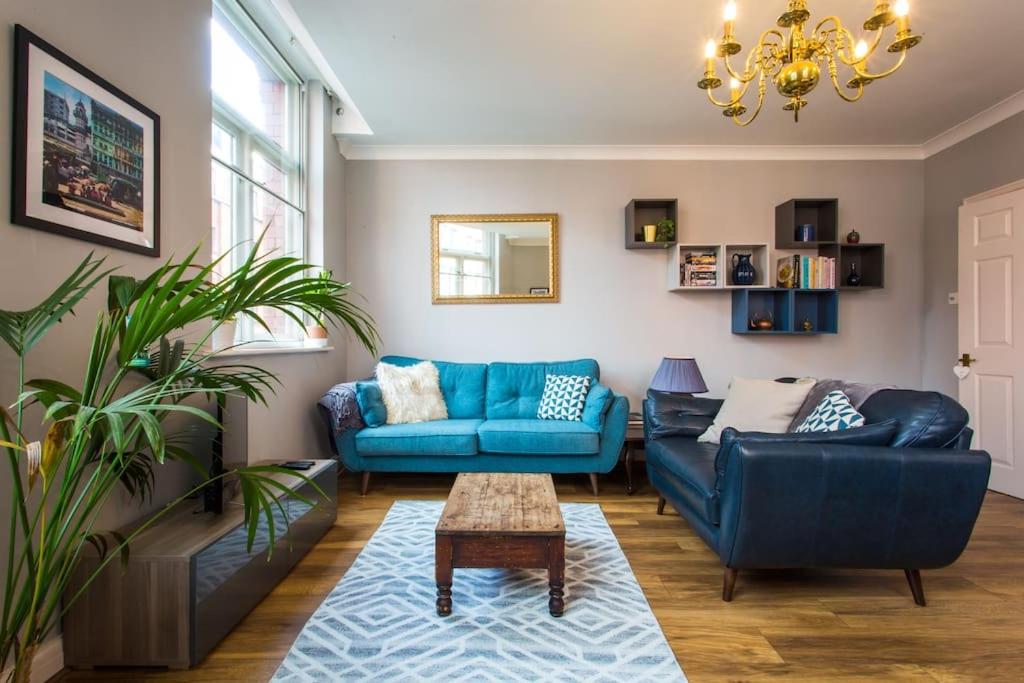 a living room with a blue couch and a table at Stylish City Centre 2 Bed Apartment - Free Parking in Manchester
