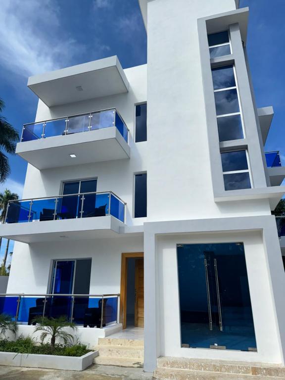 un edificio blanco con balcones azules en Luxury in Paradise 2 en San Felipe de Puerto Plata