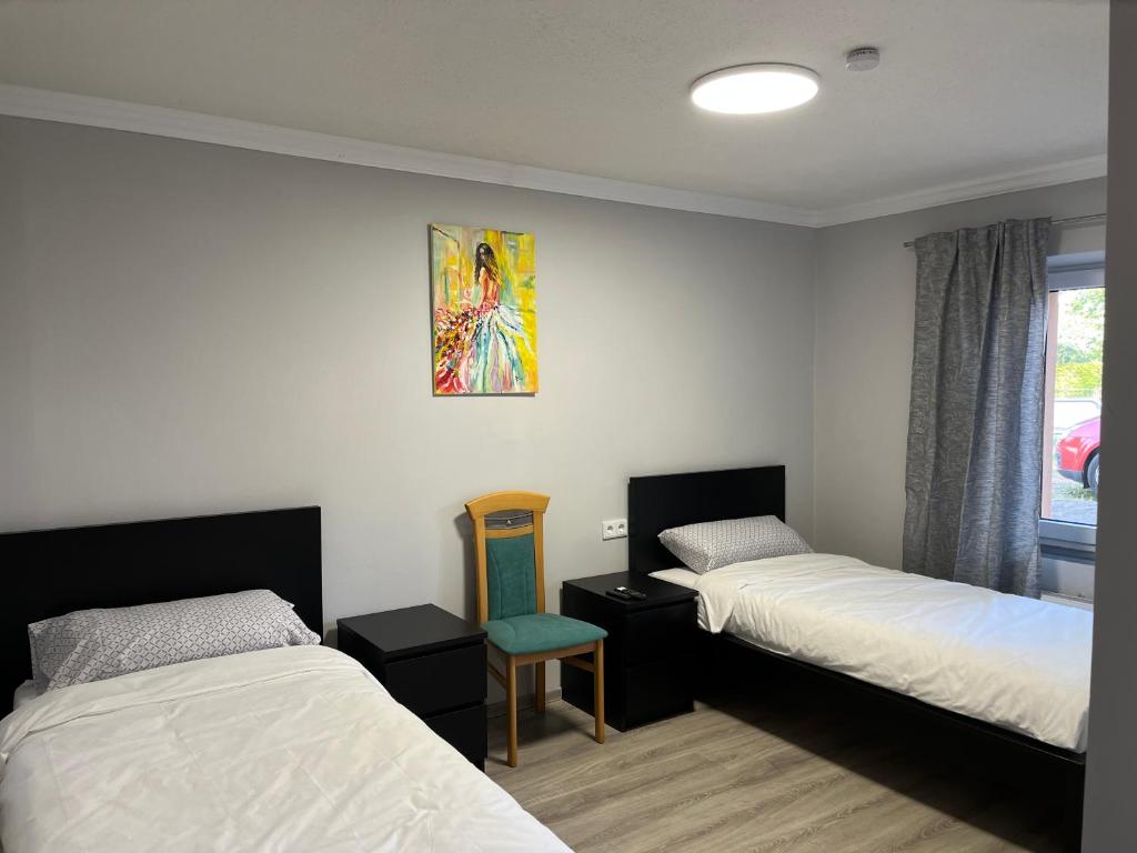 Habitación con 2 camas y una pintura en la pared. en Pension Wolkenheim, 