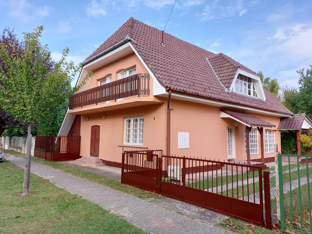 ein rosa Haus mit einem roten Zaun in der Unterkunft Holiday House Retro in Szántód