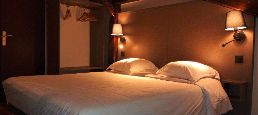 a bedroom with a white bed with two pillows at HÔTEL ROYAL MONTREUIL in Montreuil