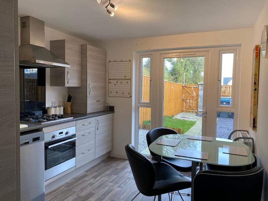 a kitchen with a table and a dining room at Modern 3bed house in central location & free parking in Aberdeen