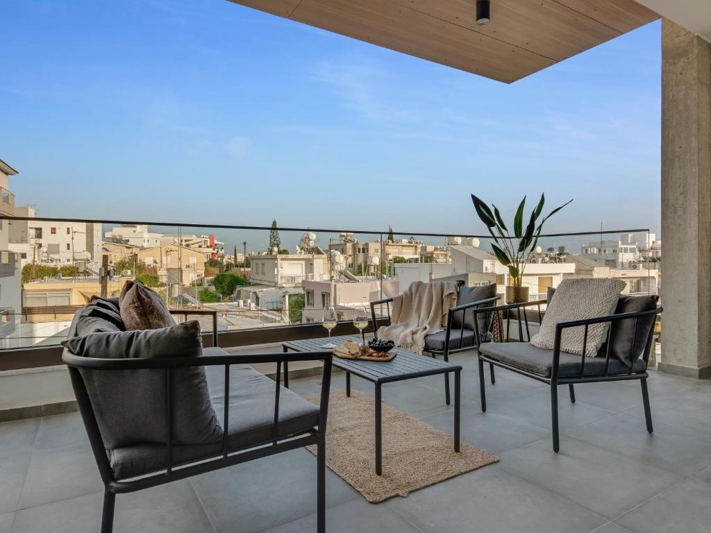 ein Wohnzimmer mit Stühlen und einem Tisch auf dem Balkon in der Unterkunft Sanders Palama Limassol in Limassol