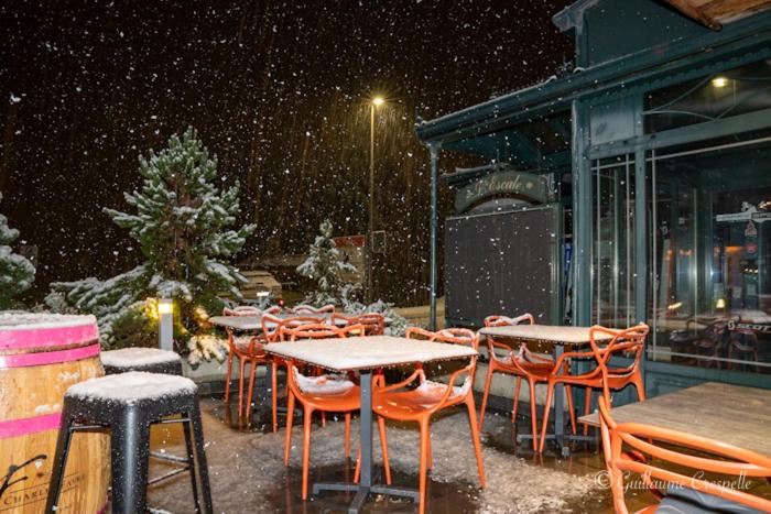a group of tables and chairs in the snow at Hôtel l’escale in Le Châble