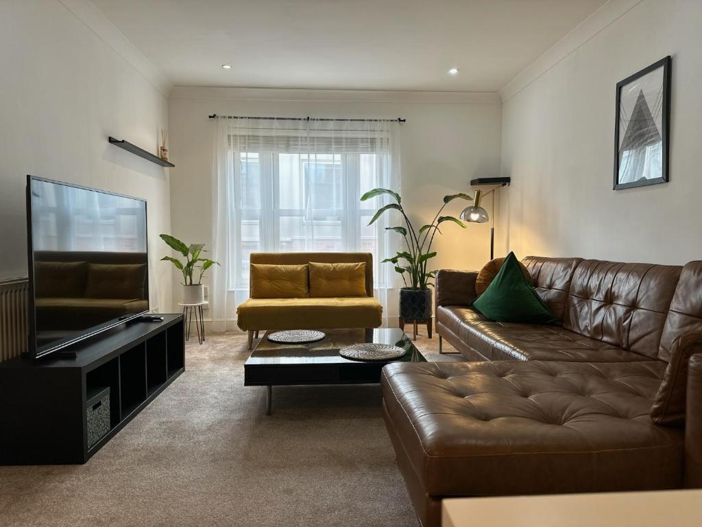 uma sala de estar com um sofá e uma televisão em Stylish One Bedroom Flat Chancery Lane em Londres