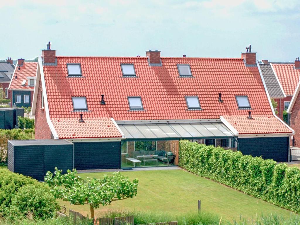 ColijnsplaatにあるModern Cottage with Sauna in Colijnsplaatの赤い屋根の大家