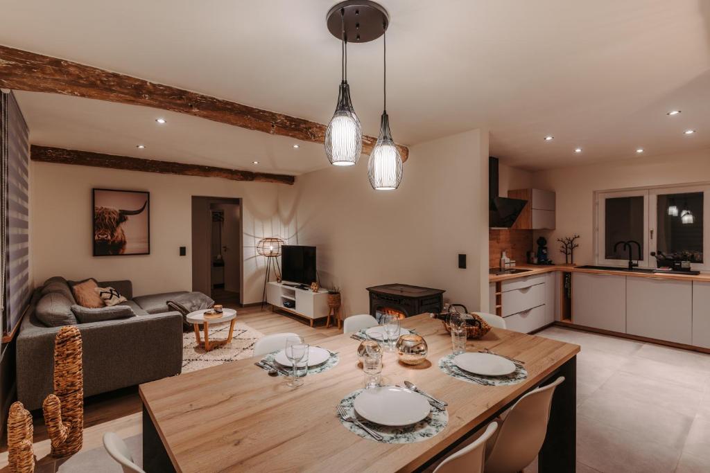 a kitchen and living room with a wooden dining table at Villa ADurbuy avec Jacuzzi in Durbuy