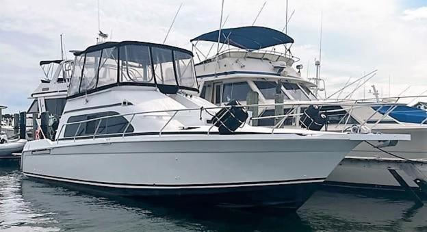 a white boat is docked in the water at Delightful 2 Bdrm Sport Yacht with Pool in Pompano Beach