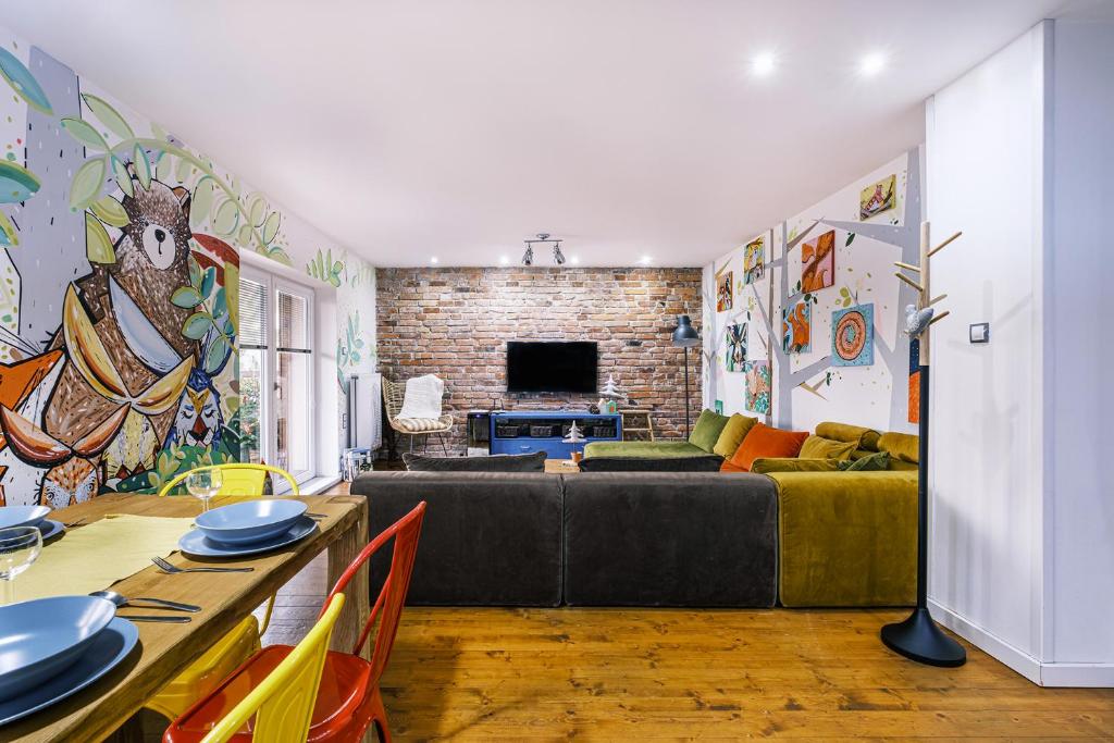 a living room with a couch and a brick wall at Apartmán V medvědím brlohu in Dolní Lomná