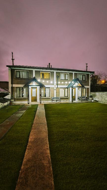 a large building with a lawn in front of it at La Herreria 2 in Esquel