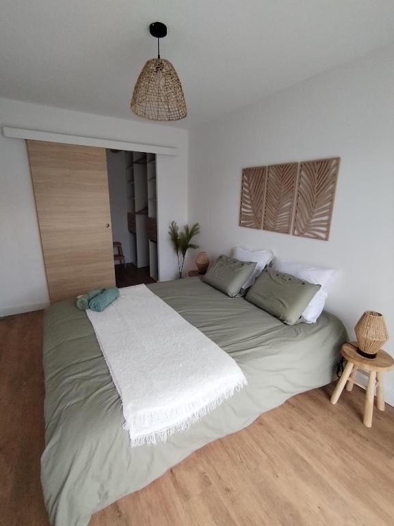 una camera da letto con un grande letto con una coperta bianca di T4 spacieux+2 terrasse vue sur picine+parking gratuit a Gagnac-sur-Garonne